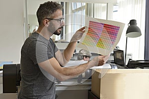 Graphic designer checks the color with color swatch.