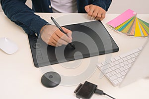 Graphic designer drawing on graphics tablet at workplace