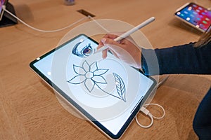 Graphic designer girl drawing sketch on digital tablet screen with stylus pencil