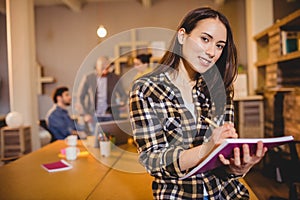 Graphic designer making notes in her diary