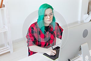 Graphic designer, people concept - Young designer female hipster with graphic tablet working in office