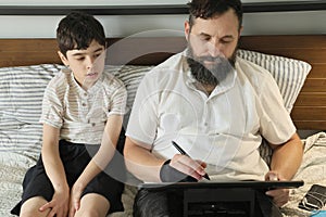 Graphic designer remote working at home, his son sitting near him