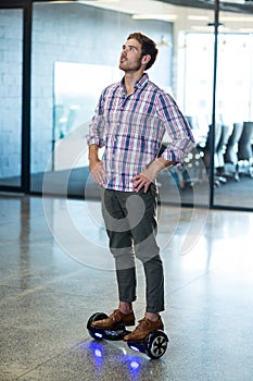 Graphic designer standing on hoverboard in office