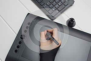 Graphic designer working on digital tablet. The hand draws on a graphics tablet. Freelance, designer, Illustrator. Technology,