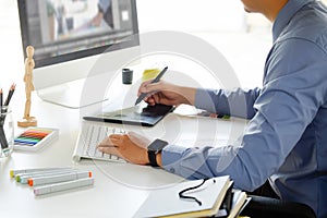 Graphic designer working with digital tablet and mouse pen on ta