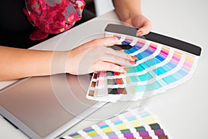 Graphic designer working on a digital tablet and with pantone