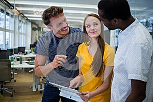 Graphic designers discussing over digital tablet