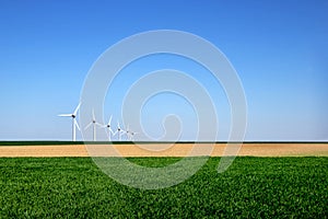 Graphic modern landscape of wind turbines aligned in a field photo