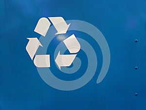 A graphic recycling symbol on a painted blue metal background.