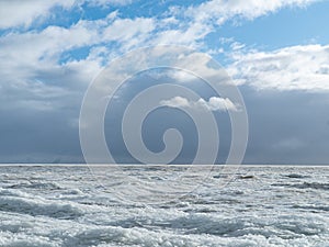 Scenery of a beautiful cloudy sky over an ice-covered pond