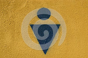 Graphic sign of men`s public toilet blue on yellow background. circle and triangle. concrete texture
