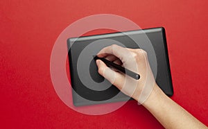 Graphic tablet for drawing and designer hand on red background. Creative art, sketch