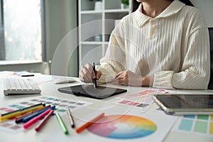 Graphic UI designer work on computer laptop and with graphic drawing pen after brainstorming unique design with