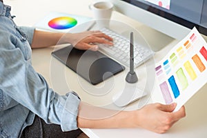 Graphic web designer does the work using a graphics tablet, desktop