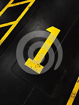 Graphic yellow numbers painted on a stark black background