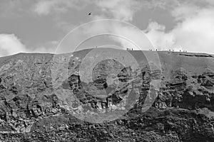 A graphical view of A group of tourists on the dangerous north edge of volcano cone of Mount Vesuvius Monte Vesuvio, Campania, I