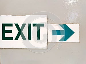 Graphically interesting exit sign on painted metal surface.