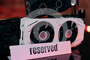 Graphics cards of different sizes and configurations on black table under neon light. Part of computer for gaming and