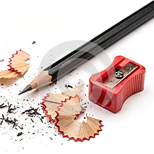 Graphite black pencil with plastic red sharpener and spiral shavings isolated on white background photo