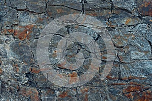 Graphite stone wall background with cracks and crevices