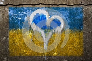 Graphite of the Ukraine flag with a heart in the middle. A painted wall.