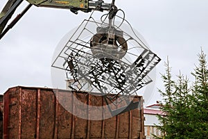 A grapple truck loads scrap industrial metal for recycling