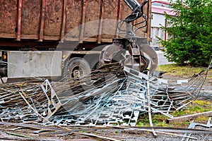 A grapple truck loads scrap industrial metal for recycling.