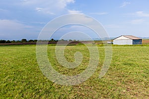 Grass airstrip plane hangar farm landscape