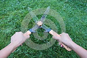 Grass cutting scissors on the grassy background