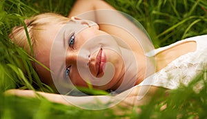 Grass field, nature portrait and happy woman relax, smile or leisure for outdoor stress relief, wellness or park break