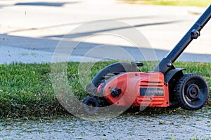 Grass flying in the air after being cut by an edger on a sunny winter afternoon