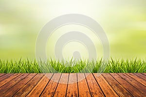 Grass with green blurred background and wood floor