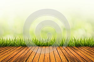 Grass with green blurred background and wood floor