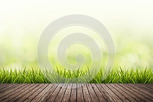 Grass with green blurred background and wood floor