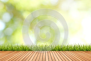 Grass with green blurred background and wood floor