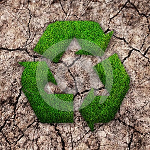 Grass recycle ecology sign on cracked earth