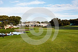 Grass, sky and trees on golf course with building, lake and natural landscape with park in summer. Nature, green and