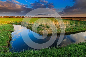 Grassland and ditch at sunset