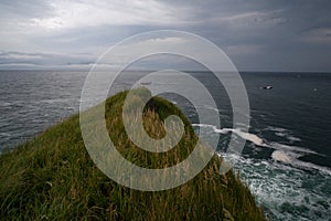 Grassy cliff above the sea.