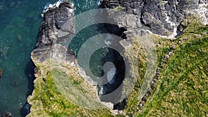 Grassy cliffs on the Atlantic Ocean coast. Landscape of Ireland from a height. Seaside rocks. Aerial photo. Drone point of view
