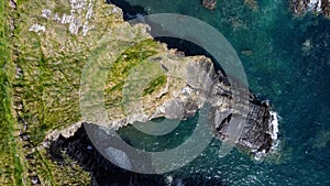 Grassy cliffs on the Atlantic Ocean coast. Landscape of Ireland from a height. Seaside rocks. Aerial photo. View from above