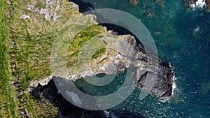 Grassy cliffs on the Atlantic Ocean coast. Landscape of Ireland from a height. Seaside rocks. Drone photo. View from above