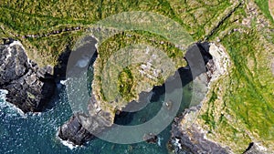 Grassy cliffs on the Atlantic Ocean coast. Landscape of Ireland from a height. Seaside rocks. Drone point of view