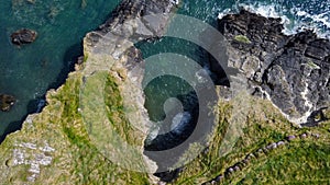 Grassy cliffs on the Atlantic Ocean coast. Landscape of Ireland from a height. Seaside rocks. View from above