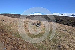 grassy field with large snow capped mountains in the background photo