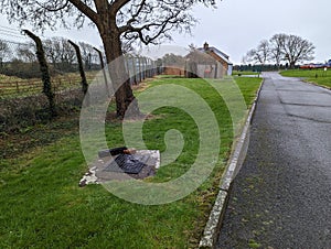 Grassy field with a manhole and building in Wales