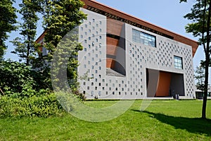 Grassy lawn before modern building at sunny summer noon