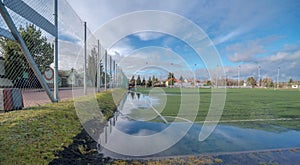 A grassy soccer pitch flooded by the waters of the winter thaw.