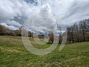 Grassy valley in the mountains with thunderstorm.