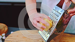 Grate yellow cheese on a cutting board